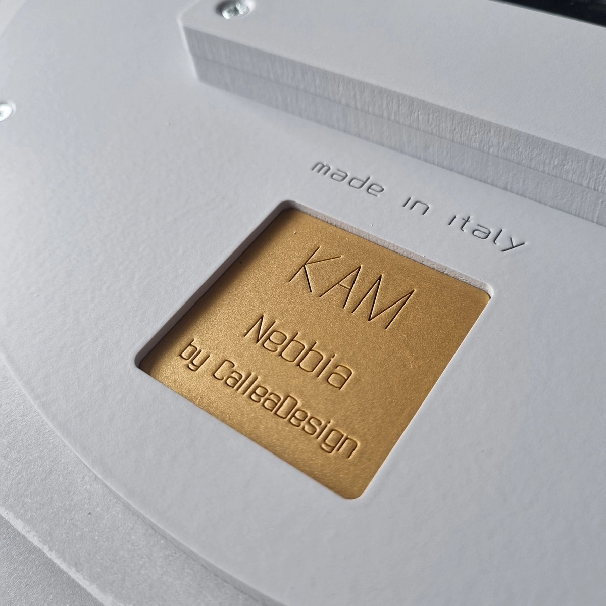 Close-up of the engraved KAM Nebbia by CalleaDesign signature and Made in Italy marking on the clock back